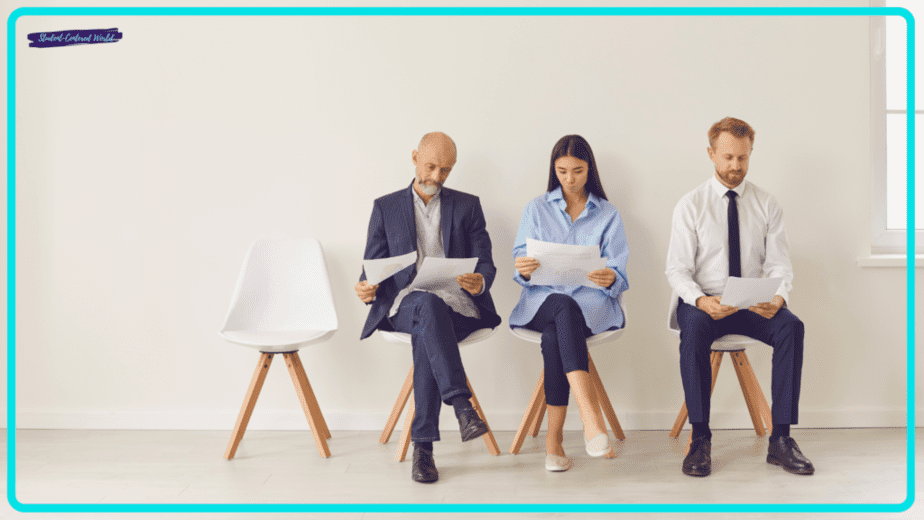 Three people seated in a row in a minimalist room, each holding papers and intently reviewing potential teacher interview questions. They sit on white chairs, dressed in professional attire, with an empty chair to their left.