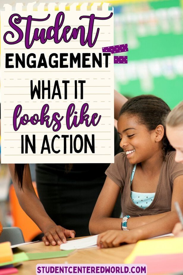 Two girls smiling and working together at a desk in a classroom, with a sign reading Student Engagement: What it looks like in action and a website link at the bottom—highlighting how student engagement is an essential part of what’s classroom management.