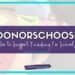 A sign with text: DonorsChoose: How to Support Funding for Schools in white and purple on a blurred background. A website link, studentcenteredworld.com, is displayed below.
