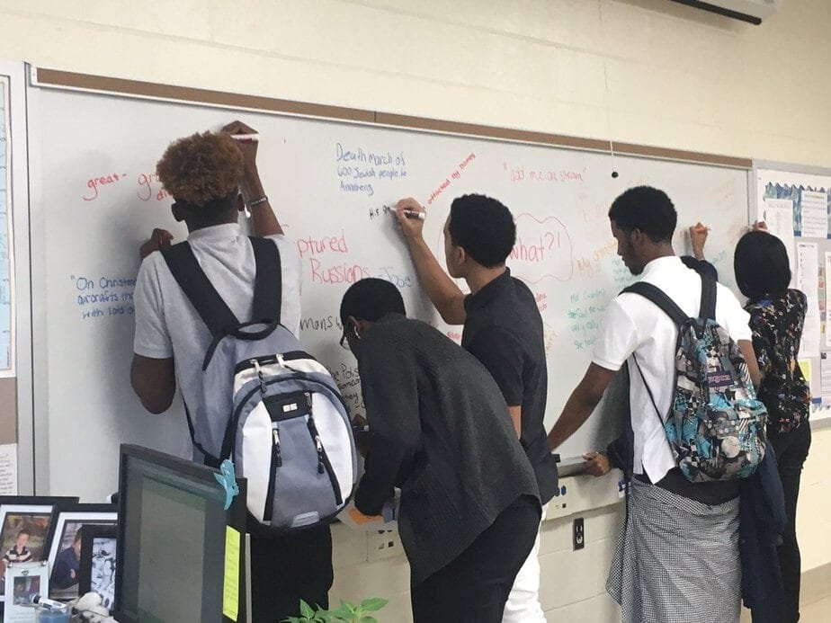 Students engaged at a whiteboard in a student-centered classroom