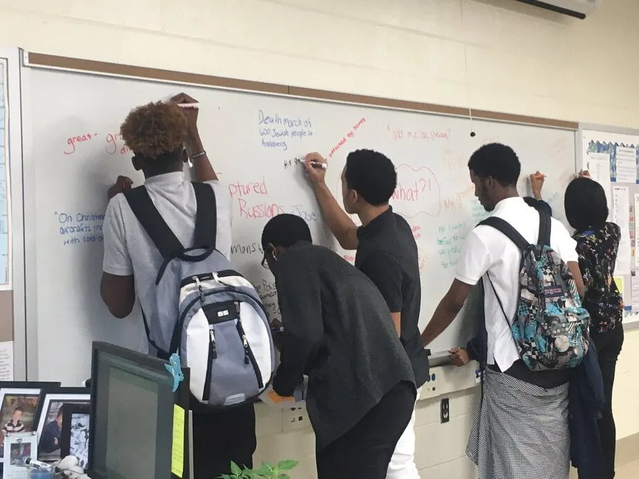 Students engaged at a whiteboard in a student-centered classroom