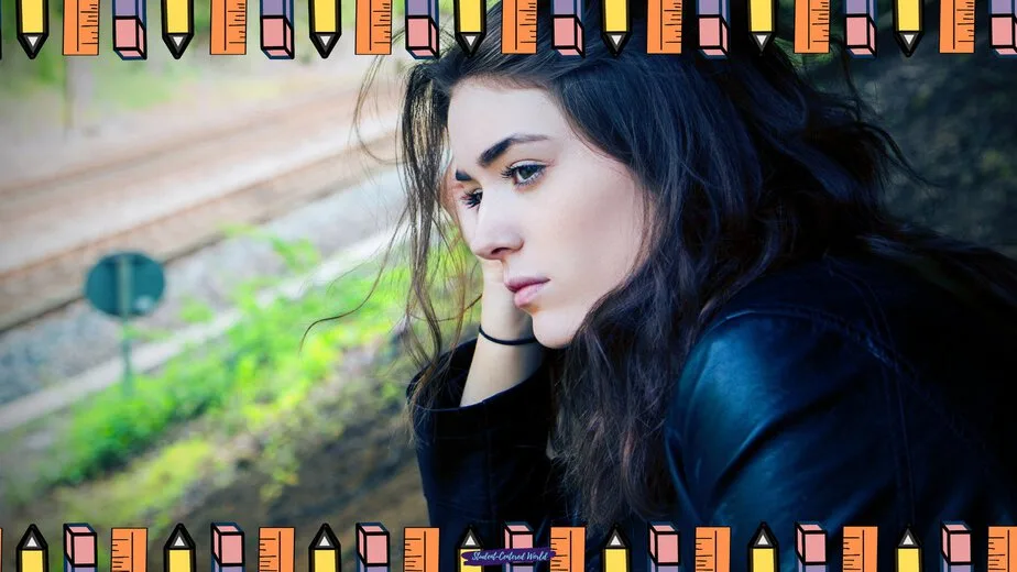 A woman with long dark hair sits outdoors, looking contemplative about why she is burnt out before school even starts. She wears a black jacket. The image is bordered by colorful pencil illustrations on the top and bottom edges. Train tracks are blurred in the background.